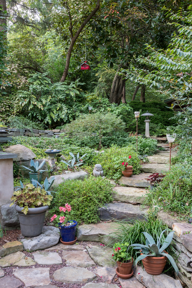 Réalisation d'un jardin arrière chalet de taille moyenne et l'été avec une exposition partiellement ombragée et des pavés en pierre naturelle.