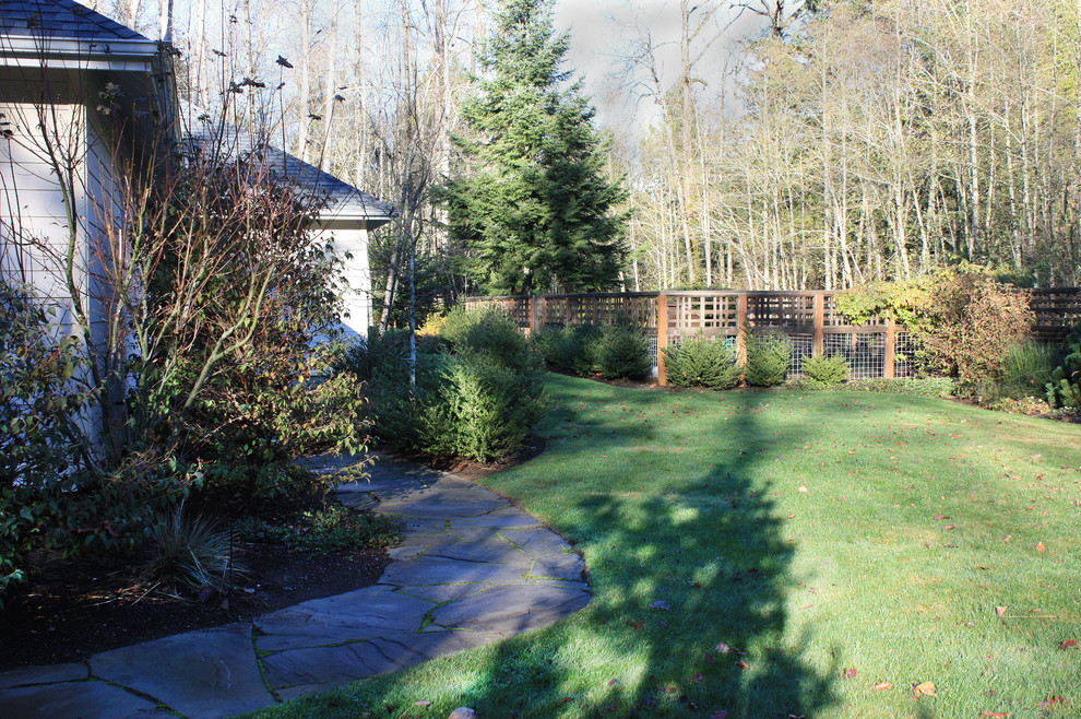 Design ideas for a mid-sized rustic full sun front yard stone landscaping in Seattle.