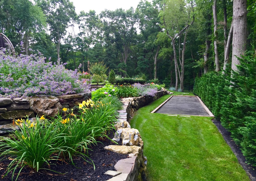 Großer, Halbschattiger Klassischer Garten im Sommer, hinter dem Haus mit Sportplatz und Natursteinplatten in New York