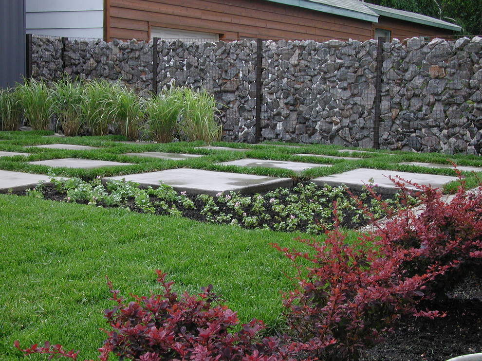 Aménagement d'un jardin arrière moderne avec des pavés en béton.