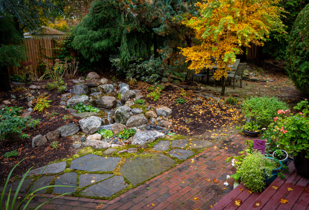 Design ideas for a small world-inspired back formal partial sun garden for autumn in Boston with a waterfall.