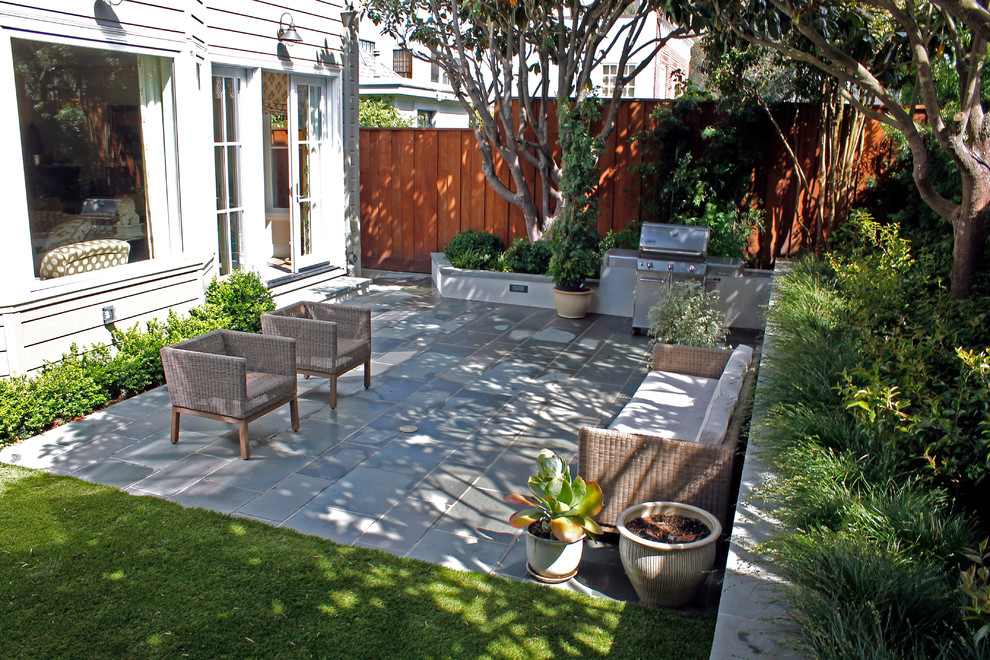 Inspiration pour un petit jardin arrière design avec un mur de soutènement et des pavés en pierre naturelle.