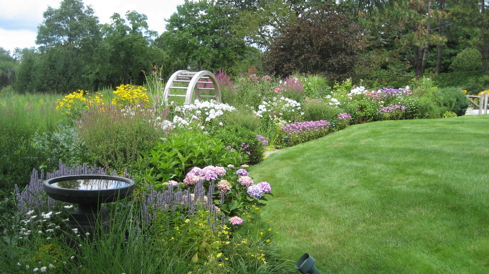 Foto de jardín clásico extra grande en verano en patio trasero con jardín francés y exposición total al sol