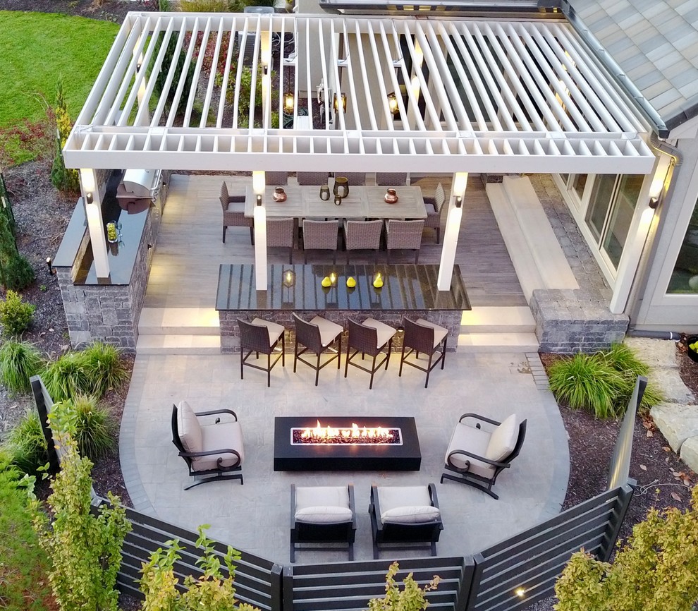 Réalisation d'une terrasse minimaliste avec un foyer extérieur et des pavés en béton.