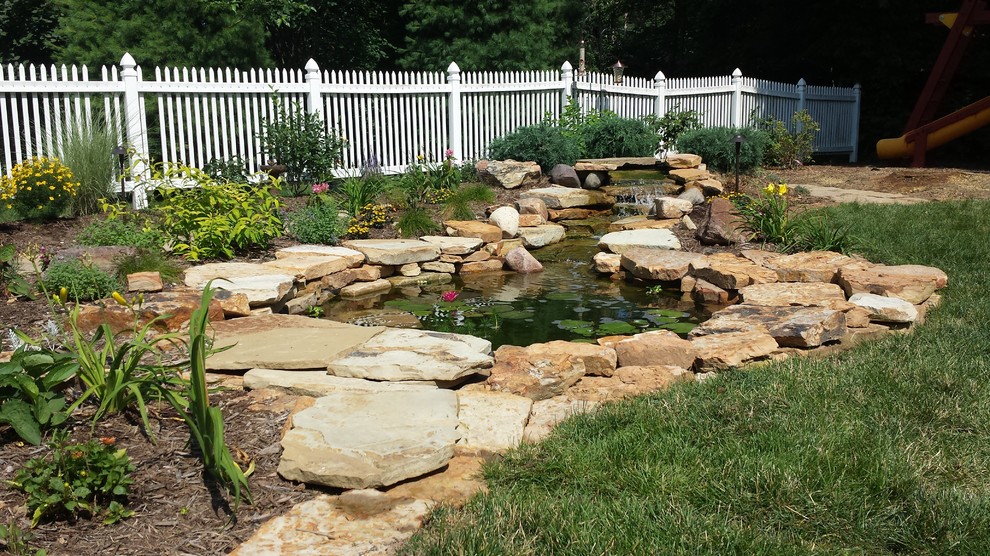 Пример оригинального дизайна: большой солнечный сад с прудом на заднем дворе в классическом стиле с хорошей освещенностью и покрытием из каменной брусчатки