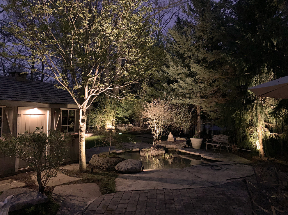 На фото: большой сад с прудом на заднем дворе в стиле неоклассика (современная классика) с покрытием из каменной брусчатки с