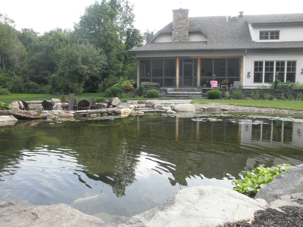 Inspiration pour un grand jardin arrière traditionnel l'été avec un bassin, une exposition ensoleillée et des pavés en pierre naturelle.