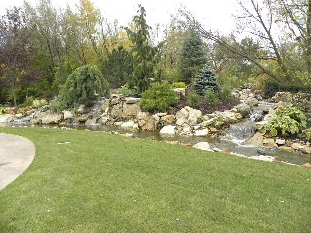 Geräumiger, Halbschattiger Klassischer Garten im Sommer, hinter dem Haus mit Wasserspiel und Natursteinplatten in Chicago