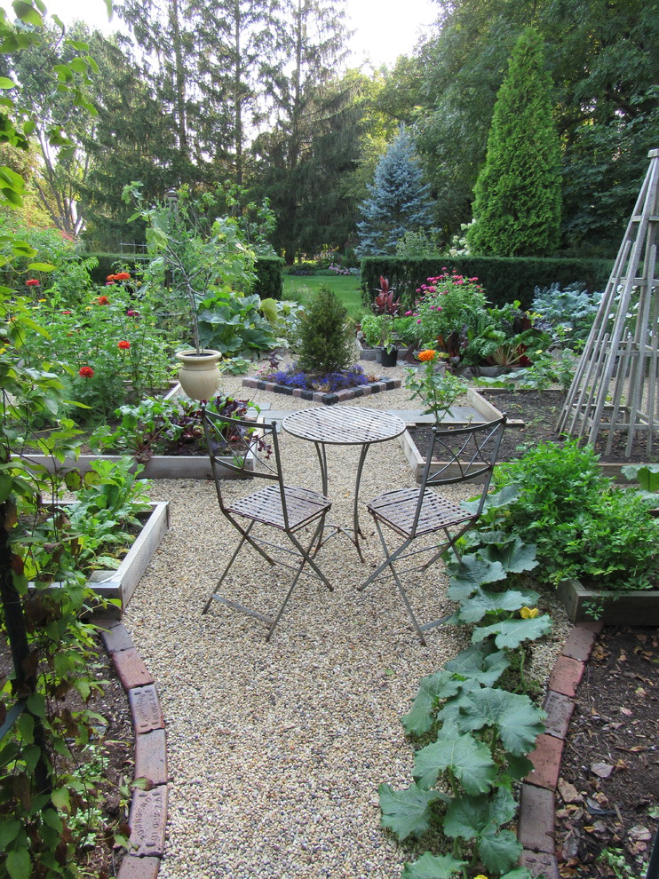 Foto på en vintage formell trädgård, med en köksträdgård och grus