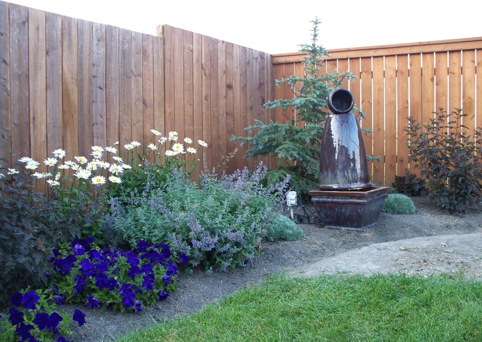 Inspiration for a traditional back full sun garden in Other with a water feature.