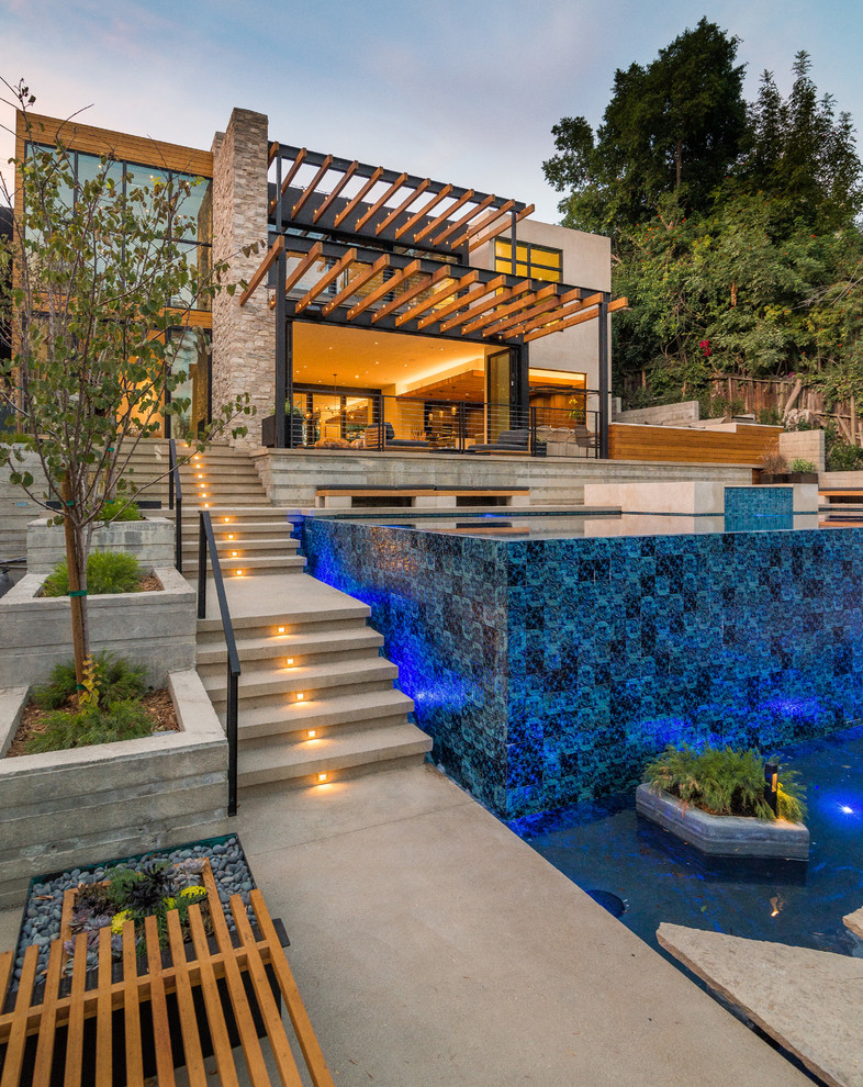Inspiration for a mid-sized contemporary partial sun backyard concrete paver landscaping in Los Angeles for summer.