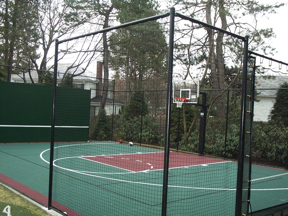 Foto di un piccolo campo sportivo esterno tradizionale esposto a mezz'ombra dietro casa con uno spazio giochi e pavimentazioni in cemento