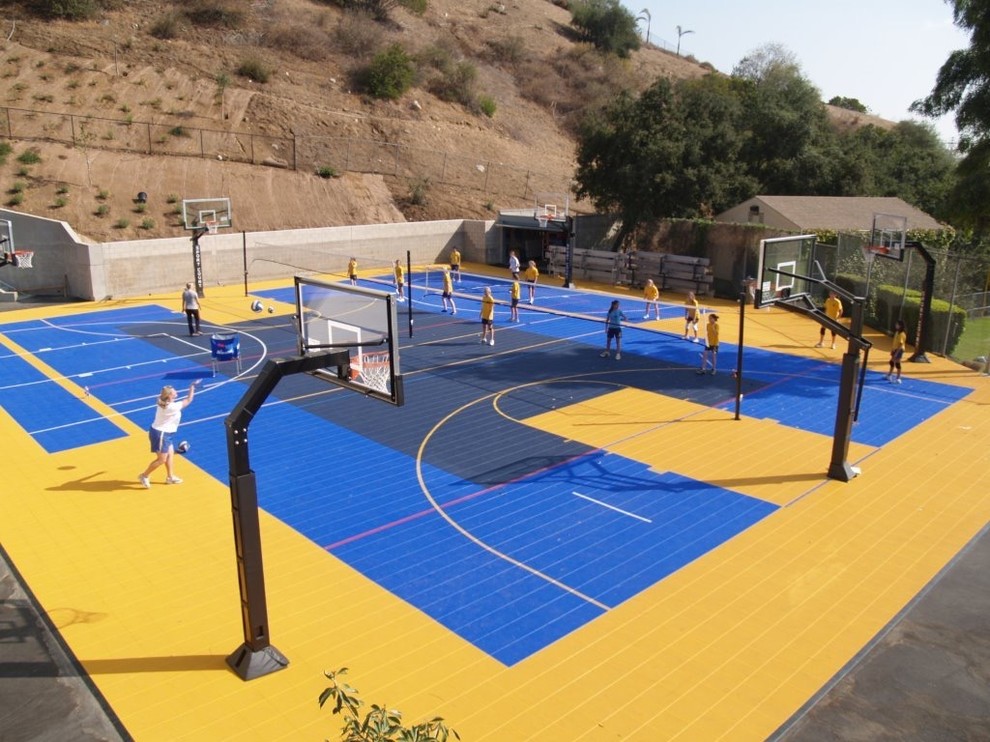 Imagen de pista deportiva descubierta moderna grande en patio trasero con parque infantil y exposición parcial al sol