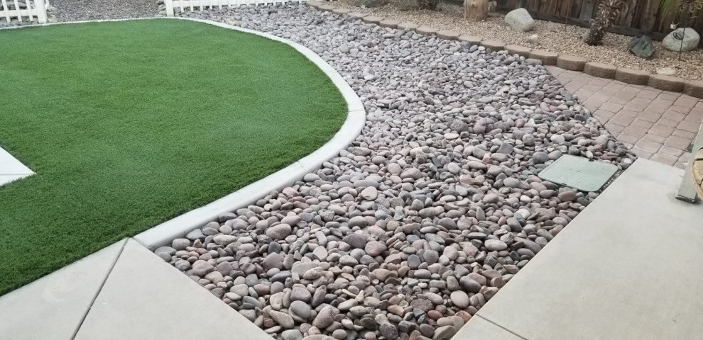 Photo of a medium sized modern back xeriscape partial sun garden for summer in Los Angeles with a desert look and decorative stones.
