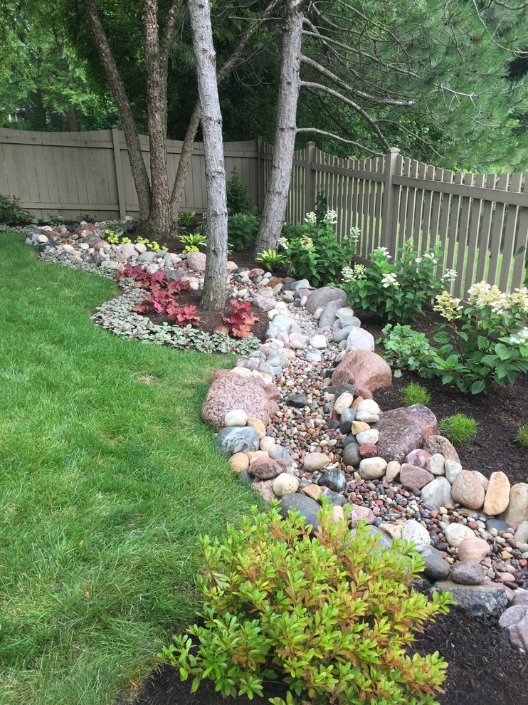 This is an example of a medium sized traditional back full sun garden for summer in Chicago with gravel.