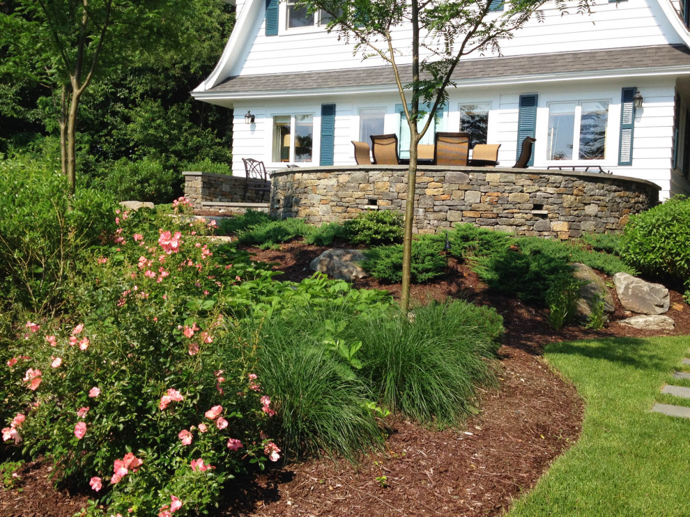 Photo of a large classic back formal full sun garden for summer in Providence with a waterfall and natural stone paving.