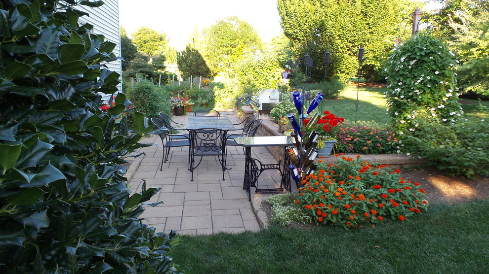 Источник вдохновения для домашнего уюта: солнечный, весенний участок и сад на заднем дворе в классическом стиле с подпорной стенкой, хорошей освещенностью и мощением тротуарной плиткой