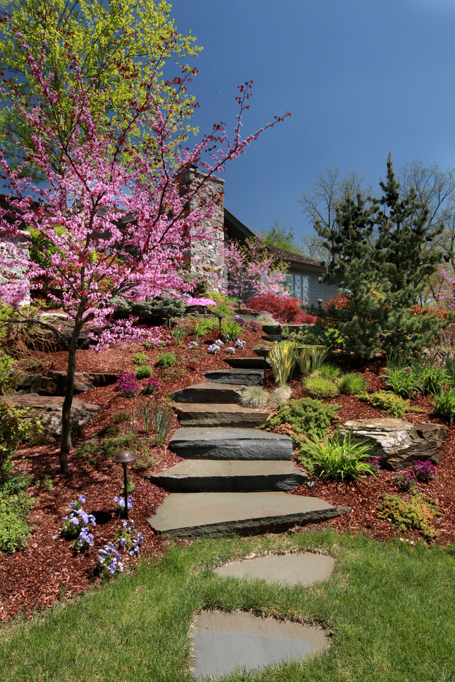 На фото: солнечный регулярный сад среднего размера на заднем дворе в классическом стиле с садовой дорожкой или калиткой, хорошей освещенностью и покрытием из каменной брусчатки с