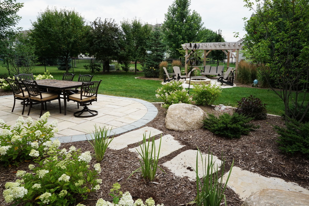 Design ideas for a mid-sized traditional full sun backyard stone formal garden in Other with a fire pit for summer.