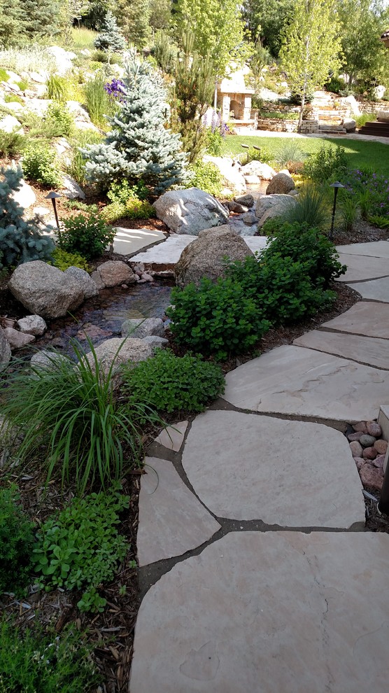 Inspiration for a medium sized classic back xeriscape partial sun garden in Denver with a water feature and natural stone paving.