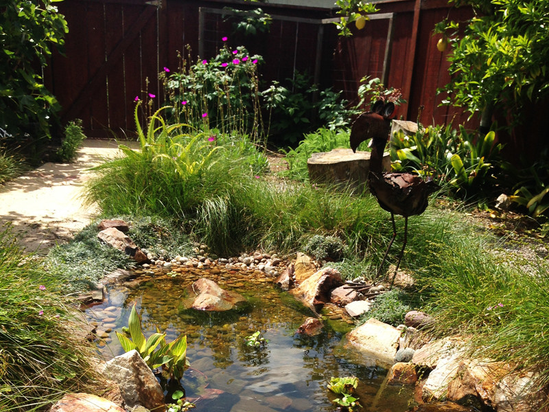 Inspiration for a mid-sized mediterranean full sun backyard stone water fountain landscape in San Diego.