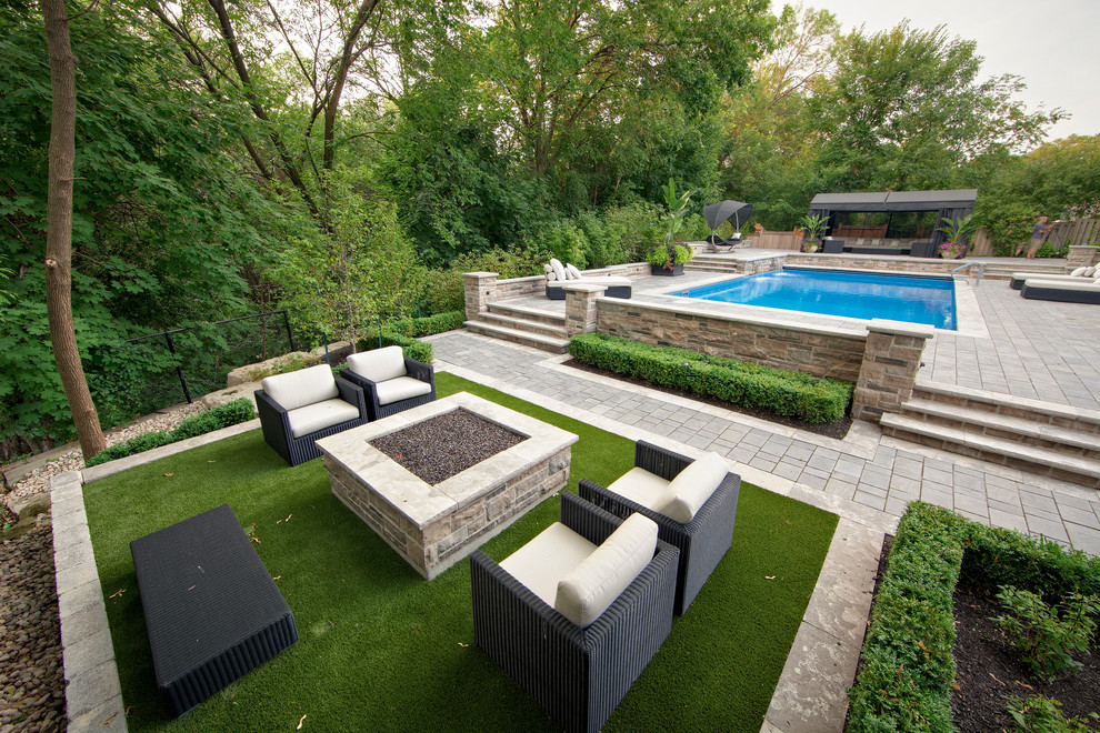 Idée de décoration pour un jardin arrière design avec un foyer extérieur.