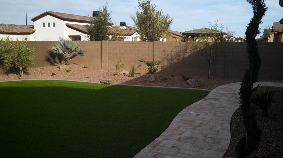 Photo of a large mediterranean drought-tolerant and full sun backyard stone landscaping in Phoenix.
