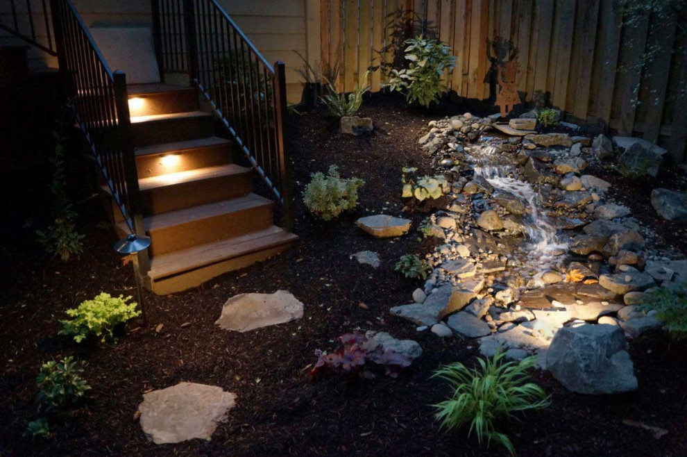 This is an example of a small modern back partial sun garden in Portland with a waterfall and concrete paving.