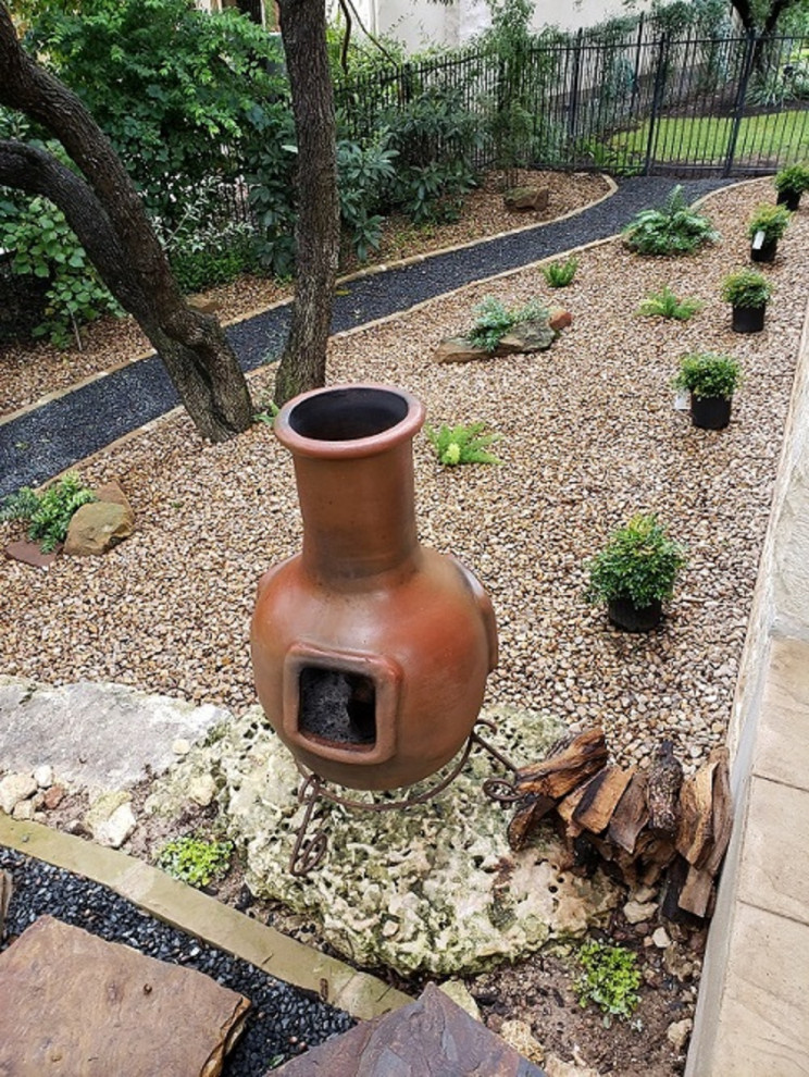 Foto de jardín de secano actual grande en patio trasero con muro de contención, exposición total al sol y piedra decorativa