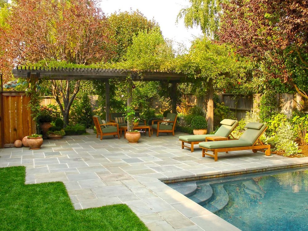 Foto di un giardino classico dietro casa con pavimentazioni in pietra naturale e recinzione in legno