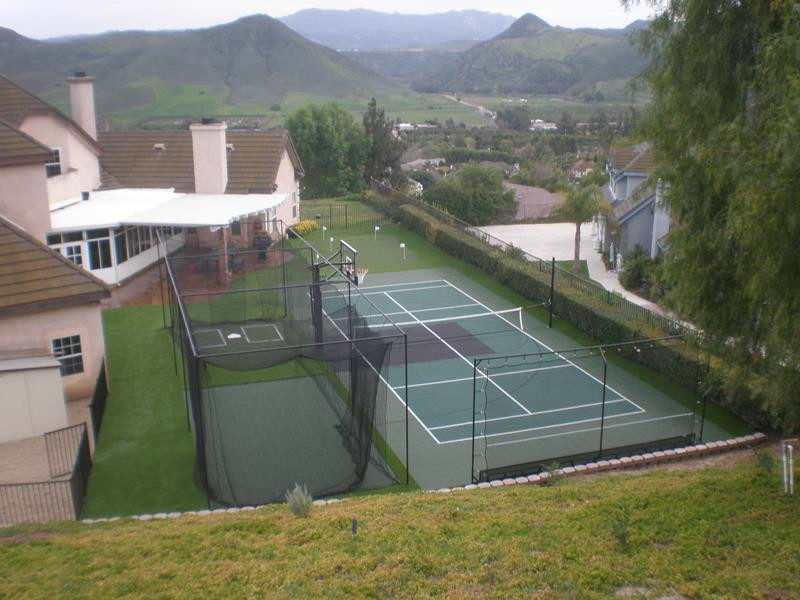 This is an example of a large modern back partial sun garden in New York with an outdoor sport court and a climbing frame.