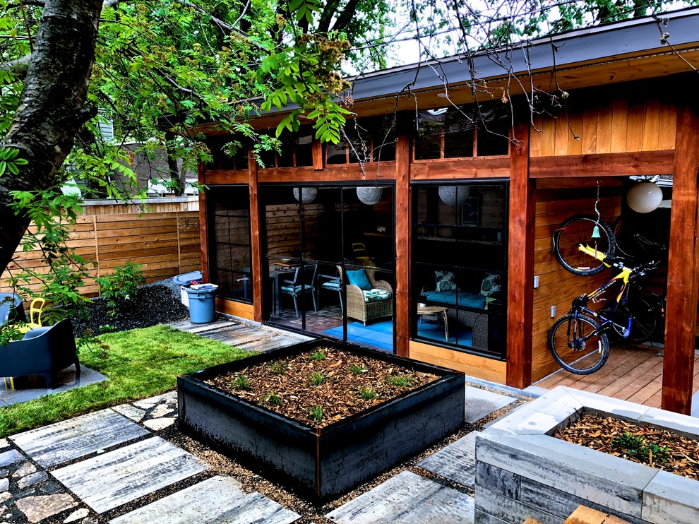 Inspiration för en funkis bakgård i delvis sol, med en öppen spis och marksten i betong