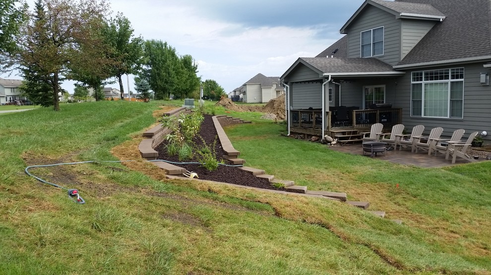 This is an example of a mid-sized backyard retaining wall landscape in Other.