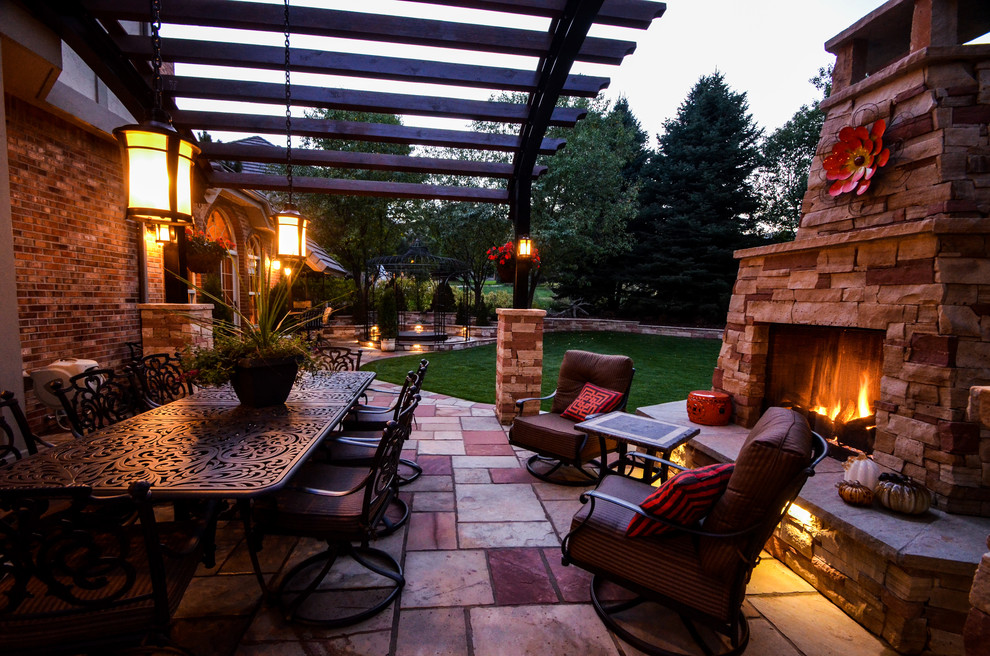 Imagen de patio clásico en patio trasero con brasero y adoquines de piedra natural