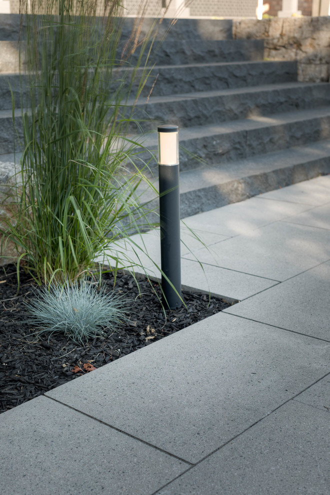 Photo of a large modern back partial sun garden in Toronto with natural stone paving.