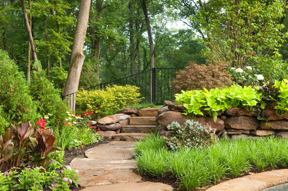 Cette photo montre un grand aménagement d'entrée ou allée de jardin chic avec des pavés en pierre naturelle.