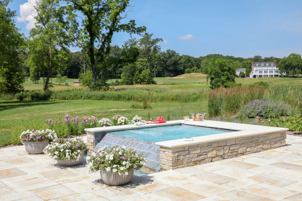 Immagine di un grande giardino minimalista esposto in pieno sole dietro casa in estate con un focolare e pavimentazioni in pietra naturale