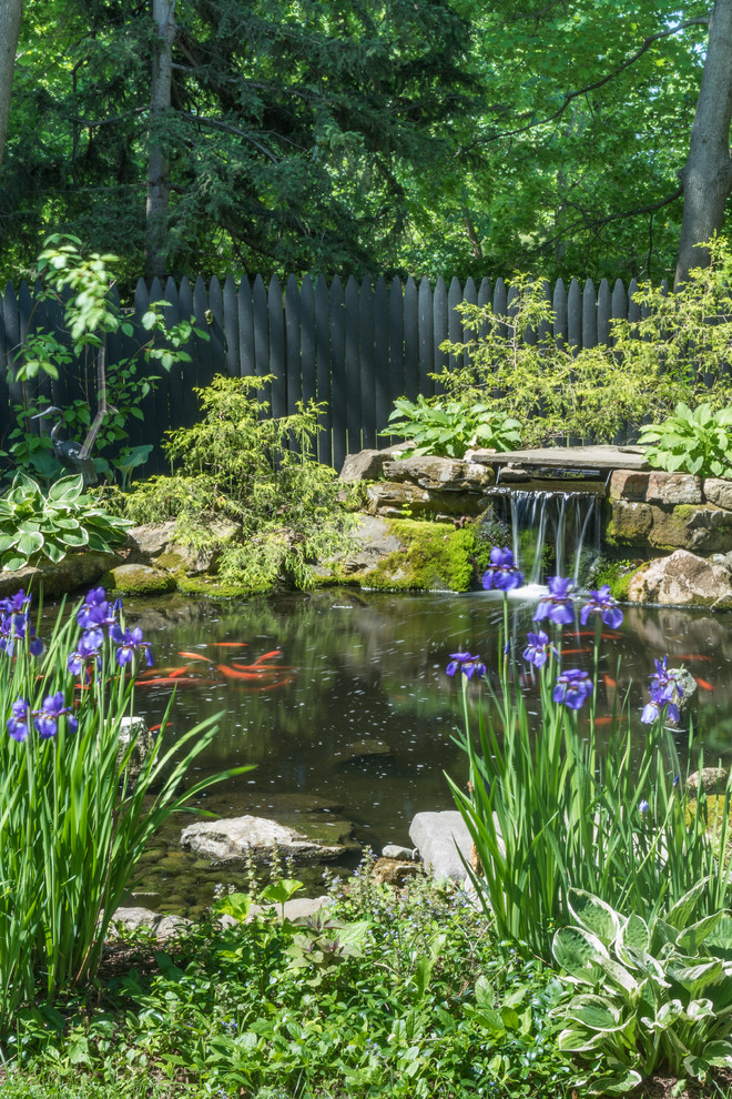 Idée de décoration pour un grand jardin à la française arrière tradition l'été avec un bassin, une exposition partiellement ombragée et des pavés en pierre naturelle.