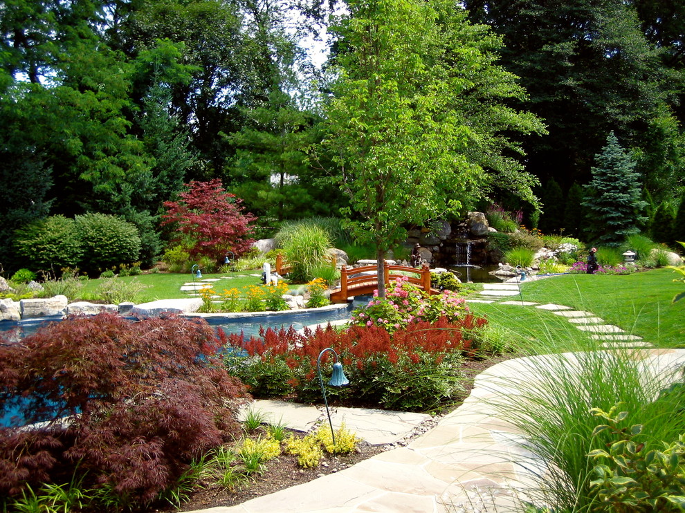 Geräumiger, Halbschattiger Klassischer Gartenteich hinter dem Haus mit Natursteinplatten in New York