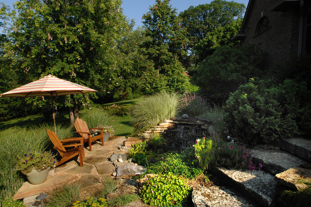 На фото: весенний участок и сад среднего размера на заднем дворе в классическом стиле с полуденной тенью и покрытием из каменной брусчатки