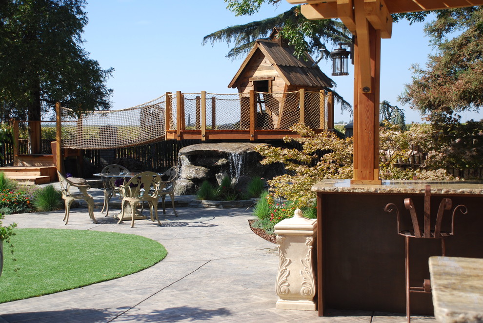 Photo of an expansive rustic back full sun garden for summer in Other with a water feature and natural stone paving.