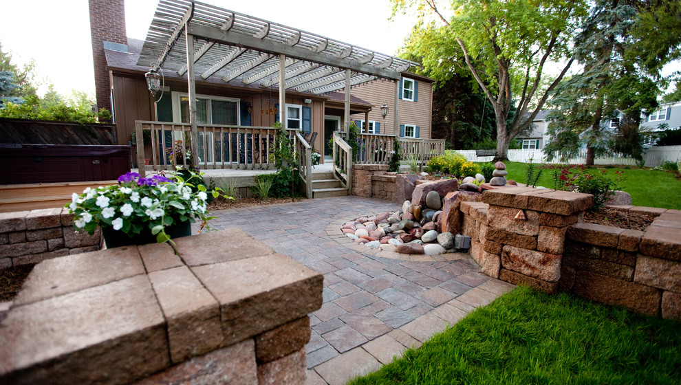 Large transitional backyard stone patio photo in Other