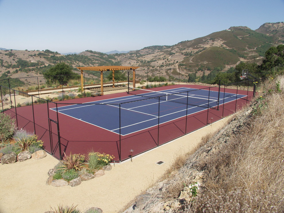 Diseño de pista deportiva descubierta mediterránea extra grande en patio trasero con exposición total al sol