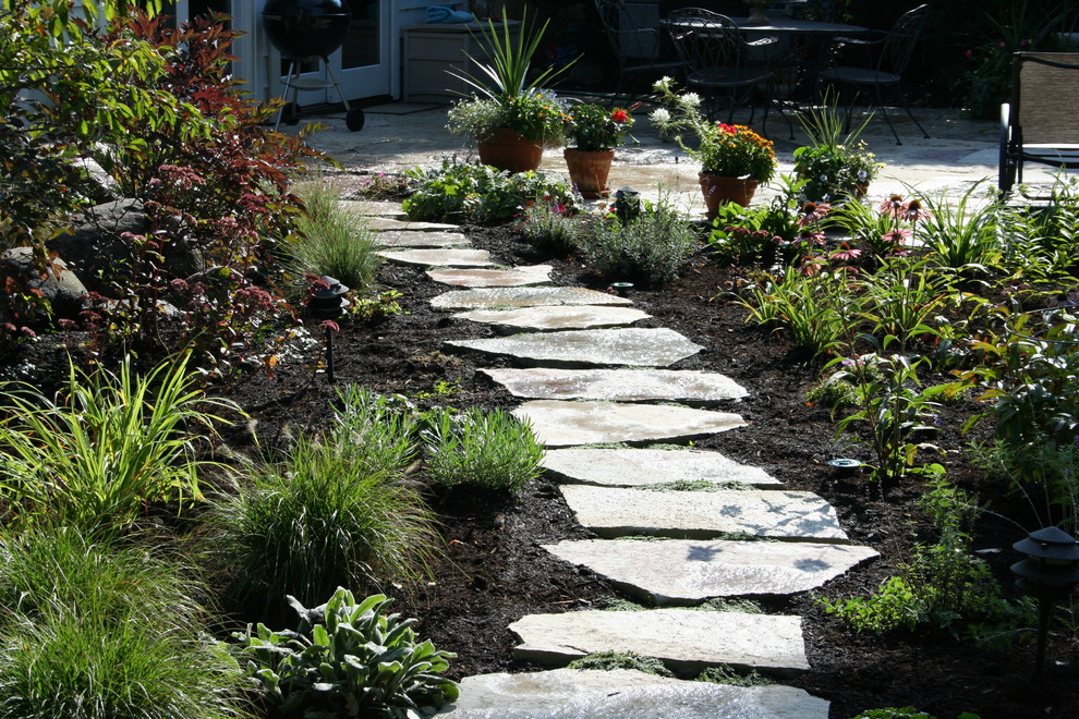 Photo of a mid-sized traditional partial sun backyard stone landscaping in Chicago.