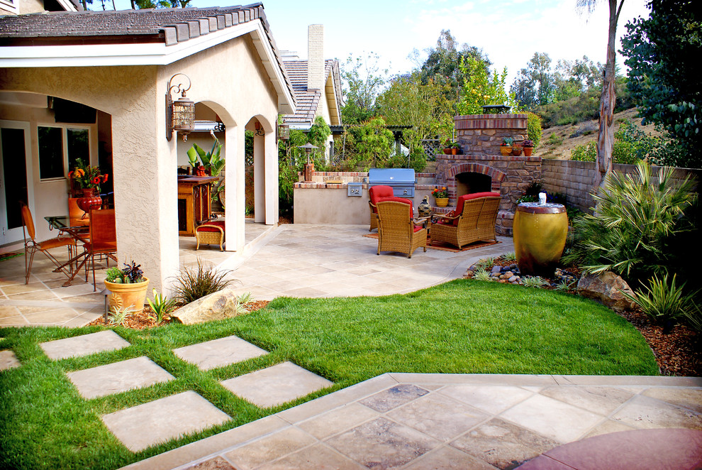 Пример оригинального дизайна: солнечный, осенний регулярный сад среднего размера на заднем дворе в средиземноморском стиле с уличным камином, хорошей освещенностью, покрытием из каменной брусчатки и с каменным забором
