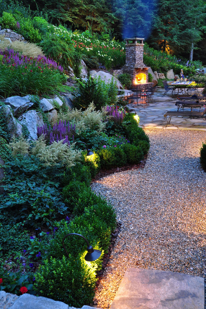 Imagen de jardín contemporáneo grande en patio trasero con brasero, exposición total al sol y adoquines de piedra natural