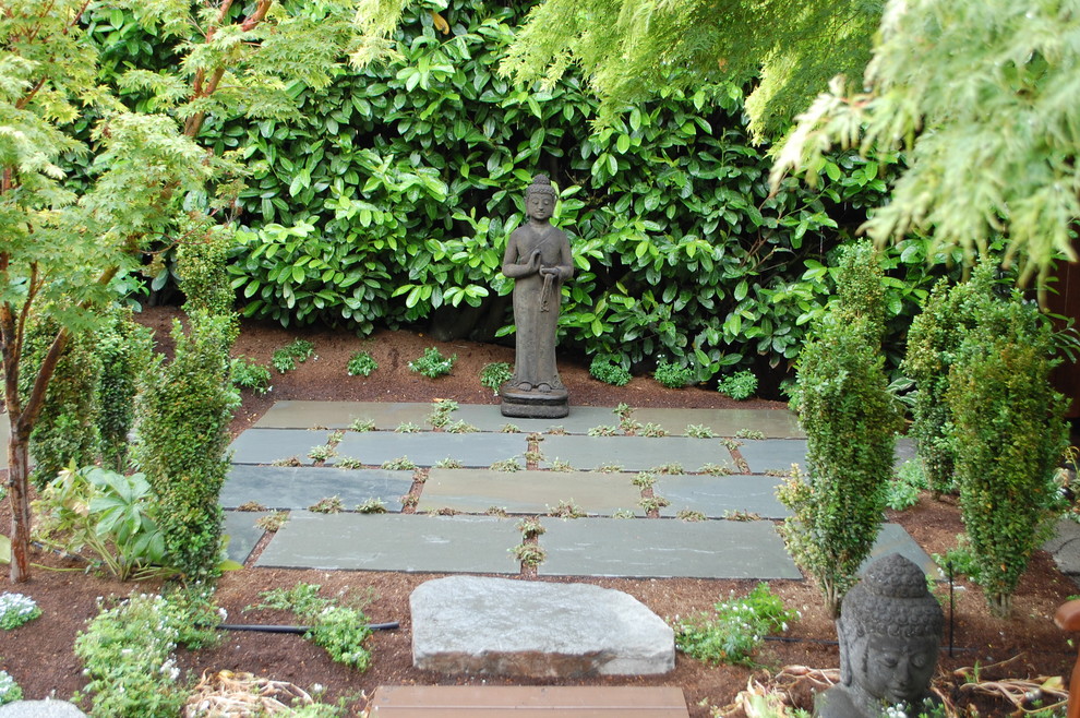 Photo of a world-inspired back fully shaded garden in Seattle with natural stone paving.