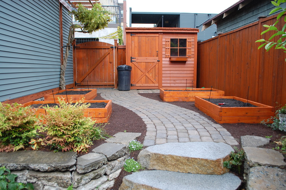 This is an example of a traditional garden in Seattle with a vegetable patch and natural stone paving.