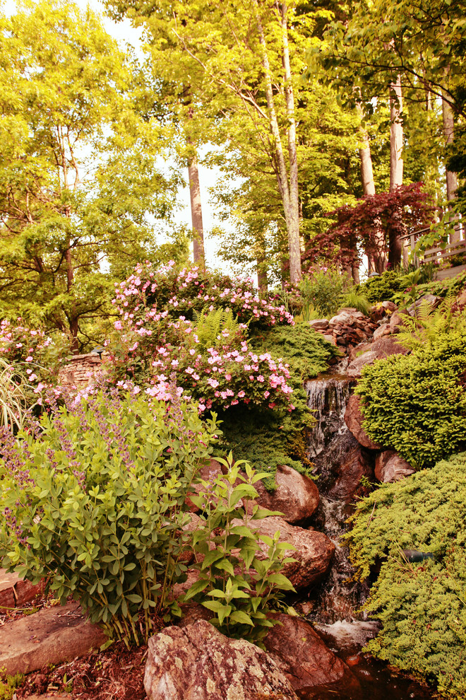 Immagine di un ampio giardino chic esposto in pieno sole nel cortile laterale in primavera con fontane e pacciame