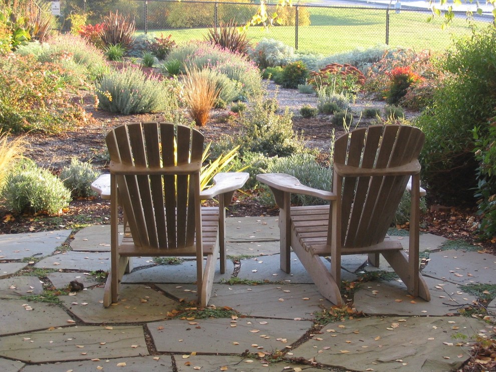 Diseño de jardín de secano rústico en patio trasero con adoquines de piedra natural